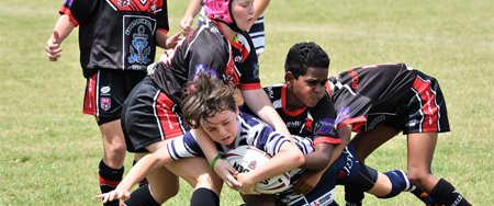 petit rugbyman qui force le passage entre trois adversaires